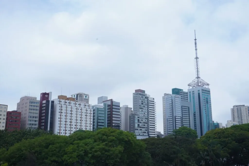 Arranha Ceus Modernos Se Erguem Acima De Arvores Verdes E Exuberantes kC9LdACj1Q4